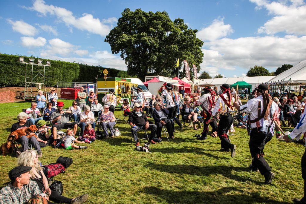 Crowds in sunshine being entertained by Silurian Morris photo by Malcolm Locker